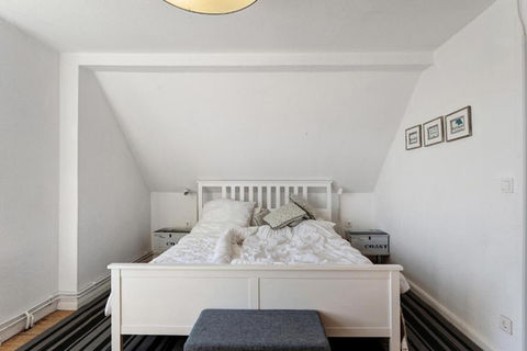 Blick auf ein 180 x 200 cm großes, beides Bett mit Kissen und Decken