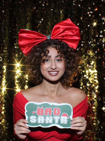 Guests enjoying a festive Christmas photo booth with holiday props