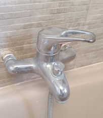 Grifería de baño con cal y suciedad acumulada, antes de una limpieza profesional