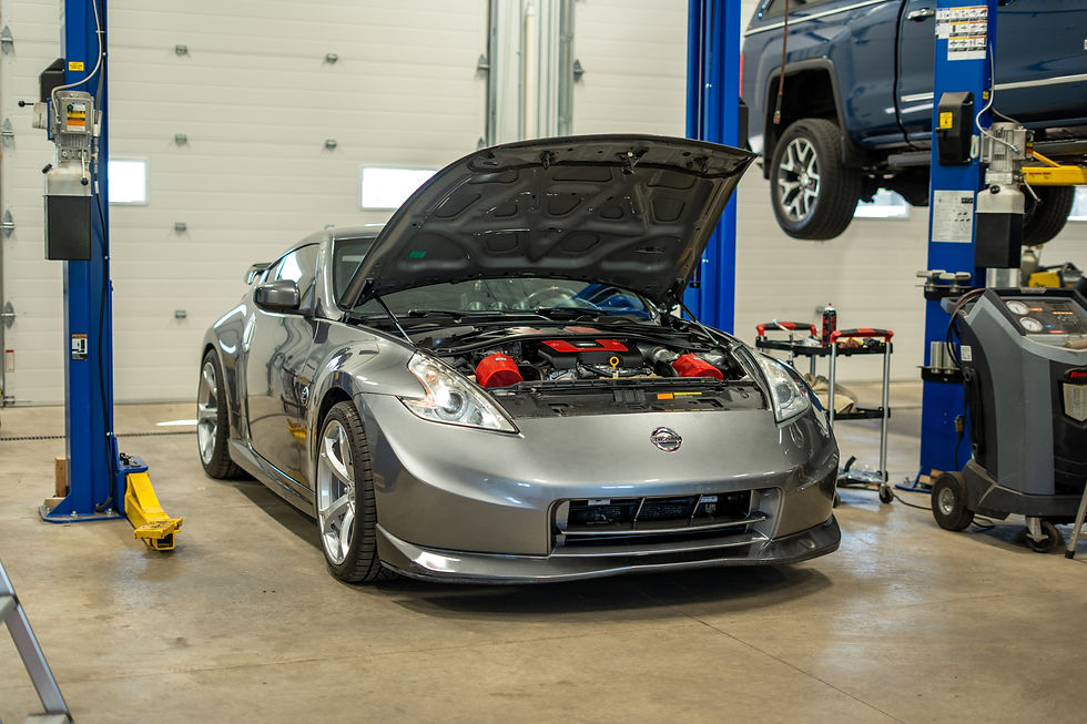 Grey Nissan 370z nismo with hood propped with red engine cover.