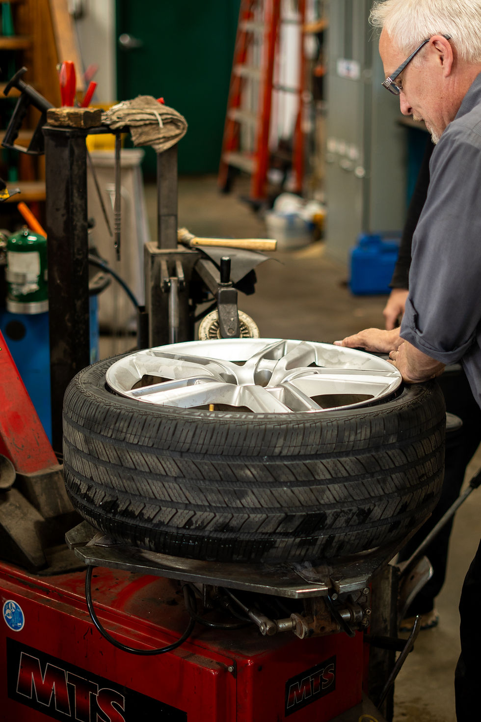 white male detaching tire from rims.
