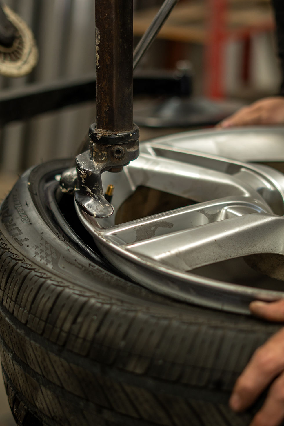 Tire machine pulling tire off showcasing valve stem.
