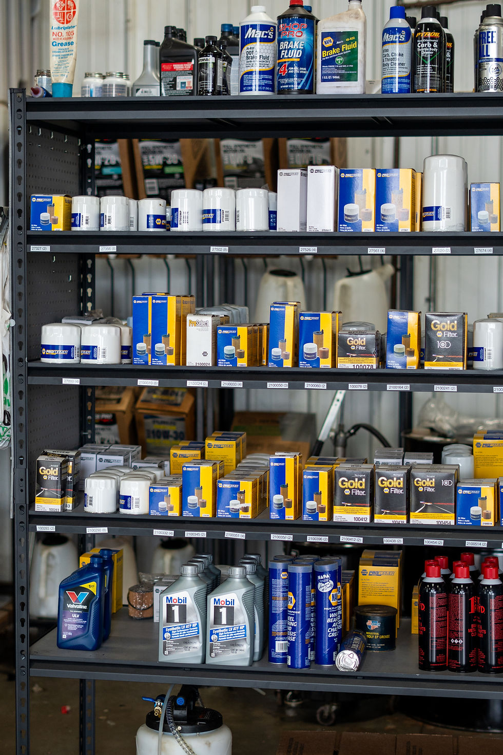 black shelf with yellow and blue oil filters (napa).