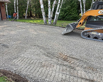 Asphalt resurfacing base preparation using heavy equipment to grade and level a residential driveway foundation