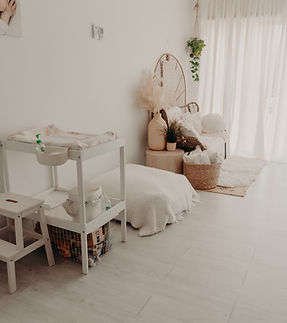 baby change table next to a posing bean bag in a white room with white flooring