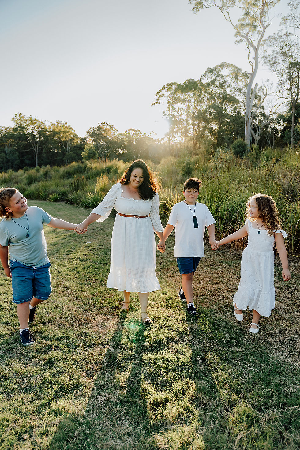 Mother walking hand in hand with 3 children whilst being photographed by Brisbane Family Photographer