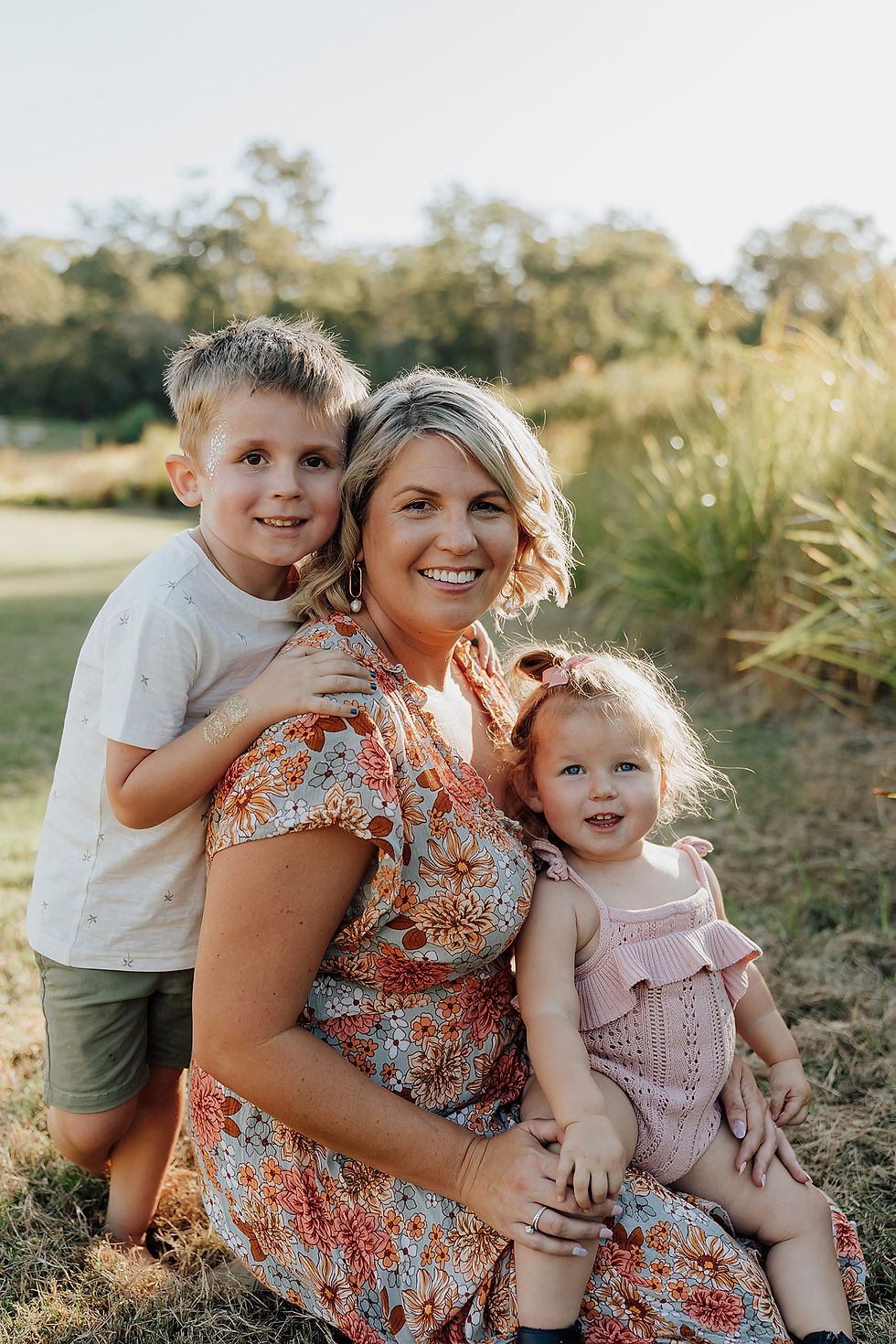 Mother sitting down having portrait taken with two children by Brisbane Family Photographer