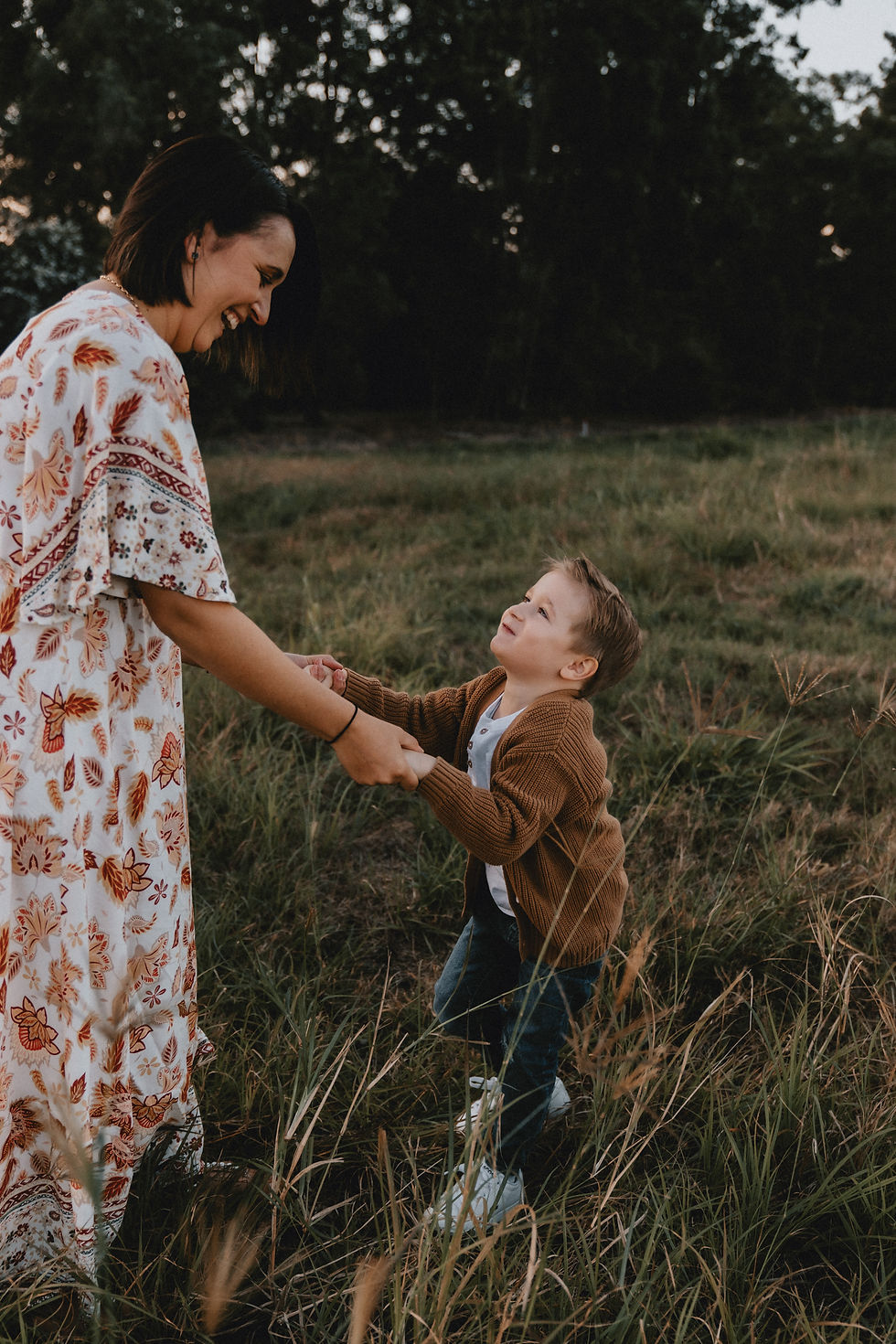 Mother and son holding hands and smiling at each other