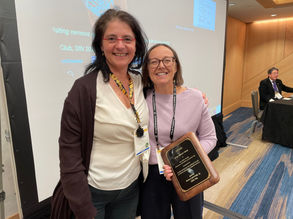 Suzana Herculano-Houzel presents Paola Arlotta with Arlotta's award plaque.