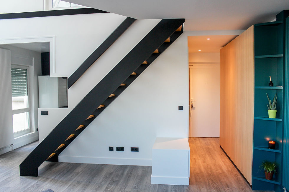 Modern interior with black diagonal staircase, wood flooring, teal shelves with plants, and warm-lit doorway in a clean home room ENGLISH-SPEAKING INTERIOR DESIGN & RENOVATION PROJECT MANAGEMENT IN FRANCE Perspectives architecture & design