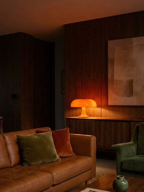 Lumière d'ambiance tamisé avec canapé en cuire confortable et profond mur en bois pour une atmosphère ambiance cosy