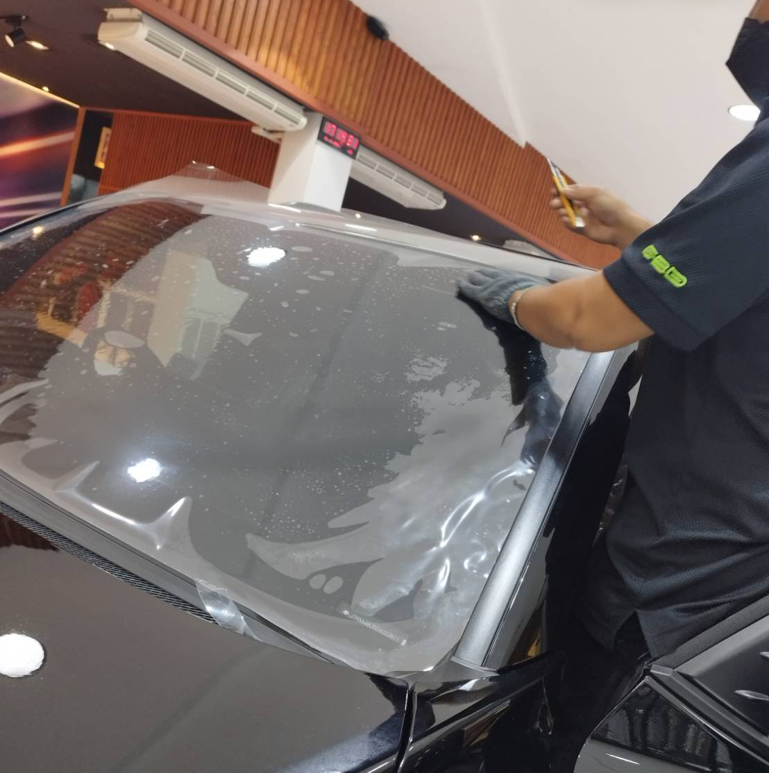 ช่างกำลังติดตั้ง EXOSHIELD GT3 บนกระจกหน้ารถ