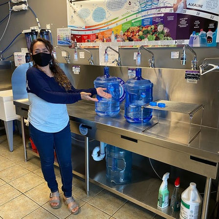 Proud alkaline water customer showing off Pasadena water boy refill station