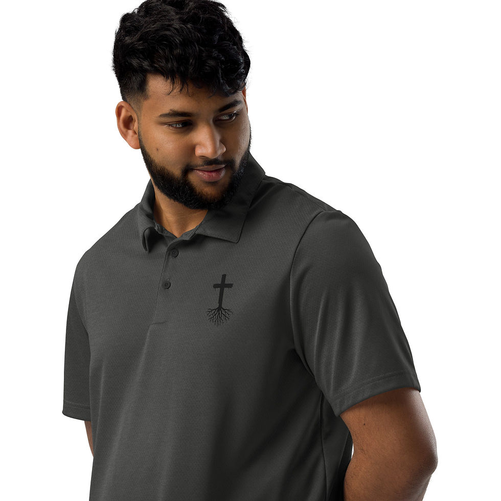 Man in dark gray cross polo shirt smiling towards the camera.