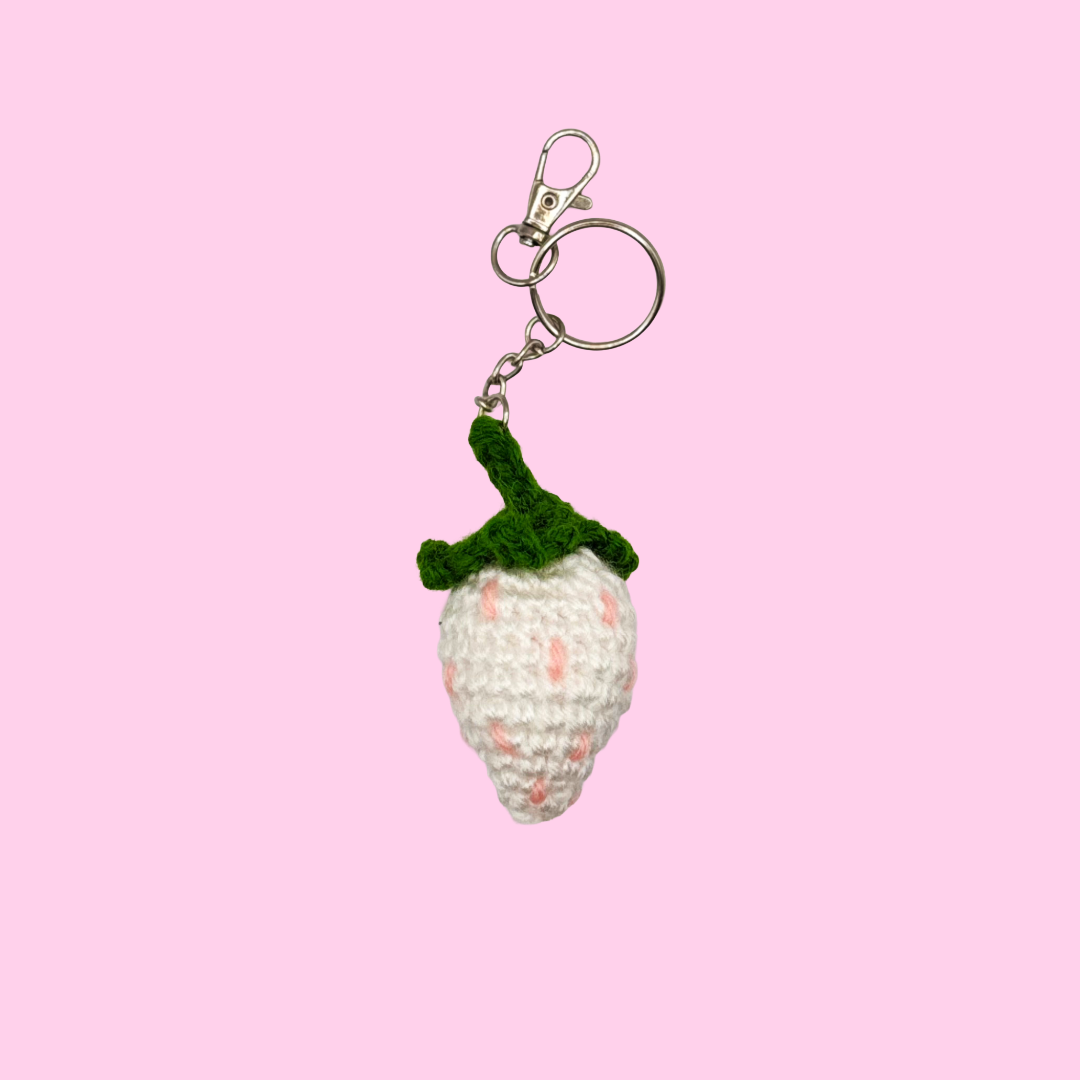 white strawberry keychain with pink background