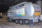 Close-up view of a waste management truck collecting trash