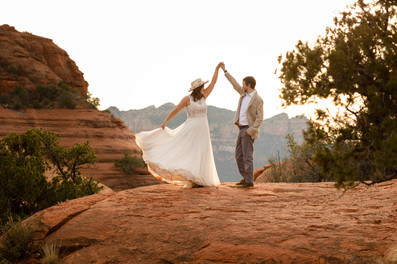 The groom twirls his bride in front of a beautiful Sedona backdrop