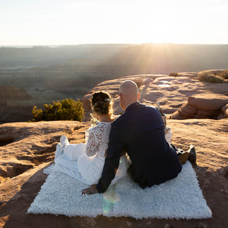 Couple looking out over Dead Horse Point at sunset