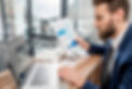 portrait-of-handsome-analytic-manager-working-with-paper-charts-and-laptop-at-the-office_e
