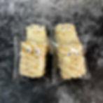 Halloween Rice Krispie treats decorated as mummies with white drizzle and candy eyes by Pixi Sweets