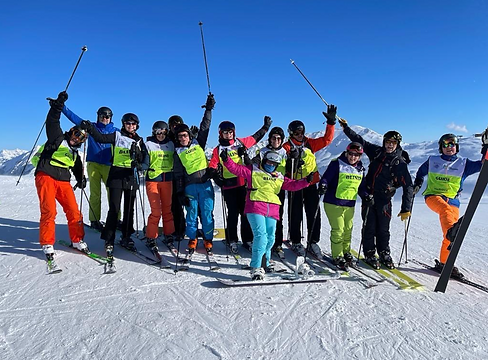 Grote groep skiers met handen in de lucht
