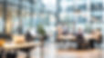 Blurred image of a modern office interior with people working at desks and in a meeting L
