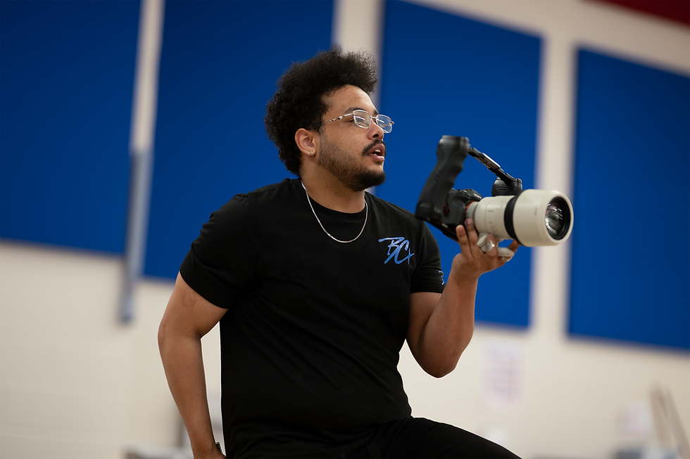 Videographer holding a camera with a professional lens.