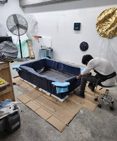 The workshop team works around the inside of the table’s composite shell.