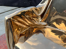 Detail of the polished bronze seat and arm of Levitaz Armchair.
