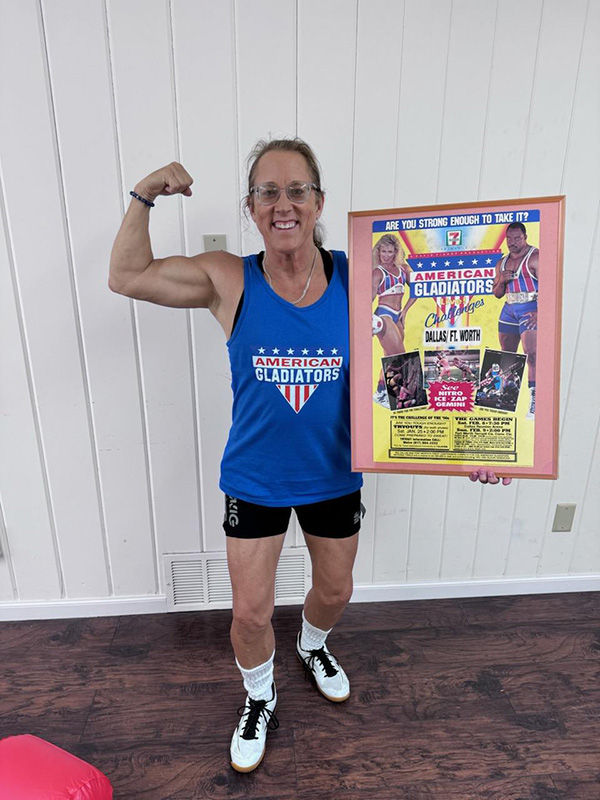 Woman flexing arm muscle holding event poster.