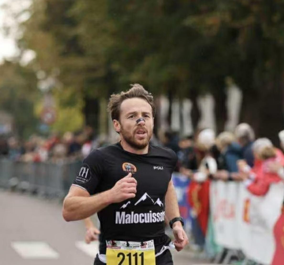 Coureur en pleine course sur route, dossard 2111