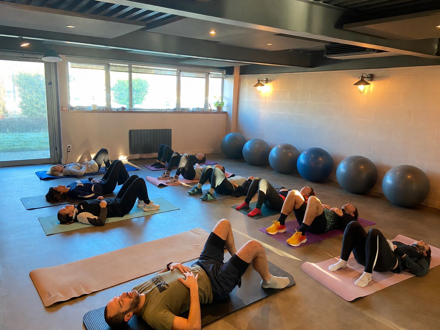 Séance au sol dans une salle chaleureuse avec ballons de gym