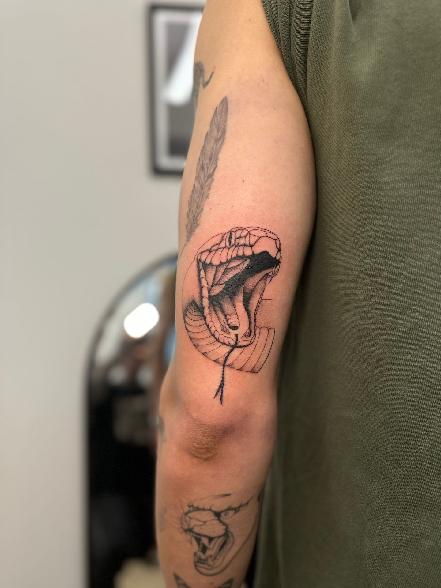 a man has a tattoo of a snake on his arm