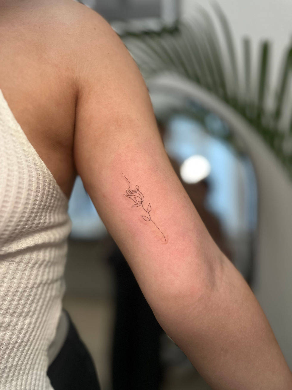 a woman has a tattoo of a rose on her arm