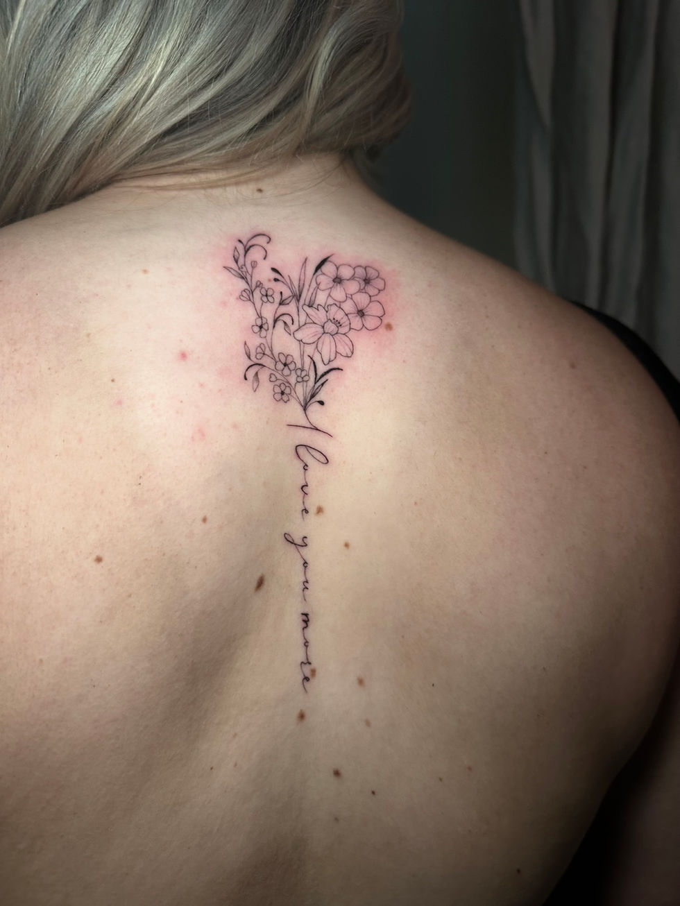 a woman has a tattoo on her back that says love you more