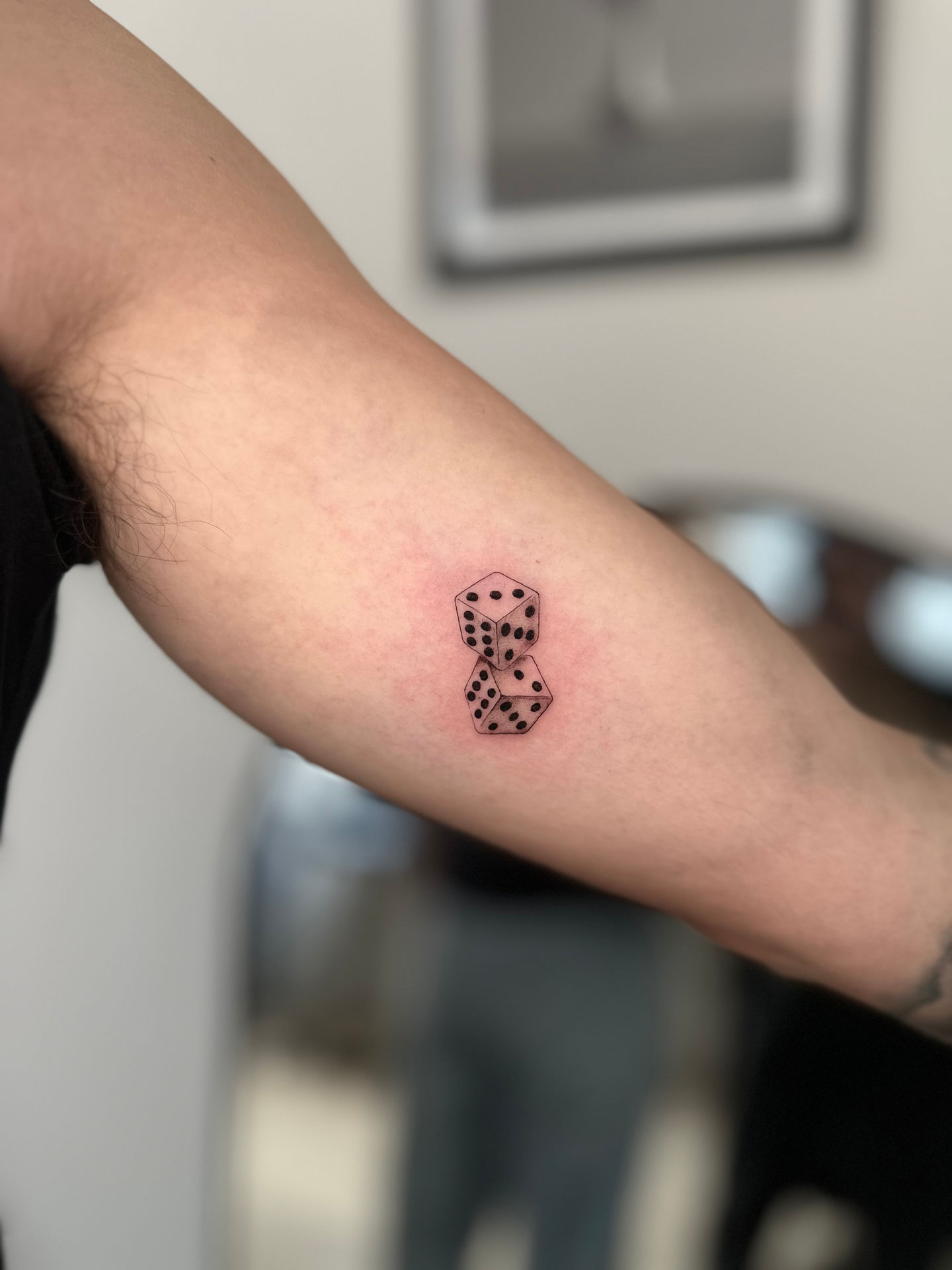 a person has a tattoo of dice on their arm