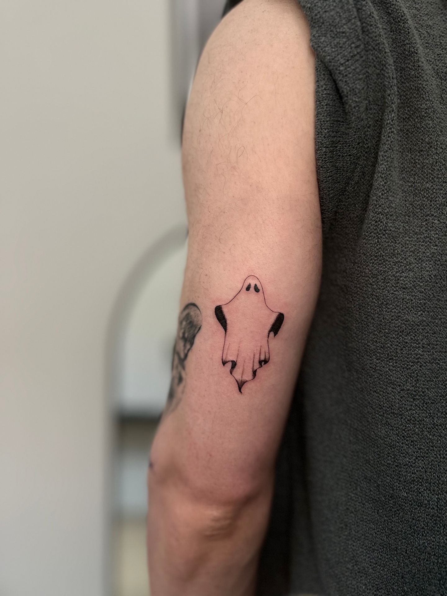 a person has a tattoo of a ghost on their arm