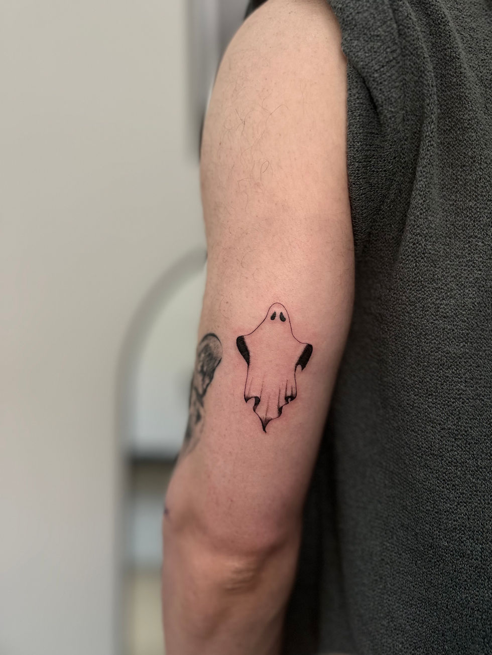 a person has a tattoo of a ghost on their arm