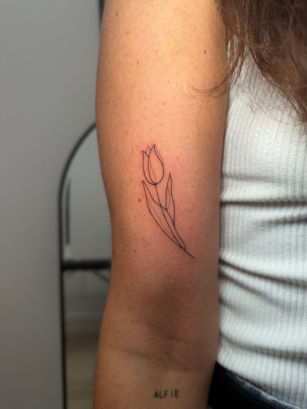 a woman has a tattoo of a tulip on her arm