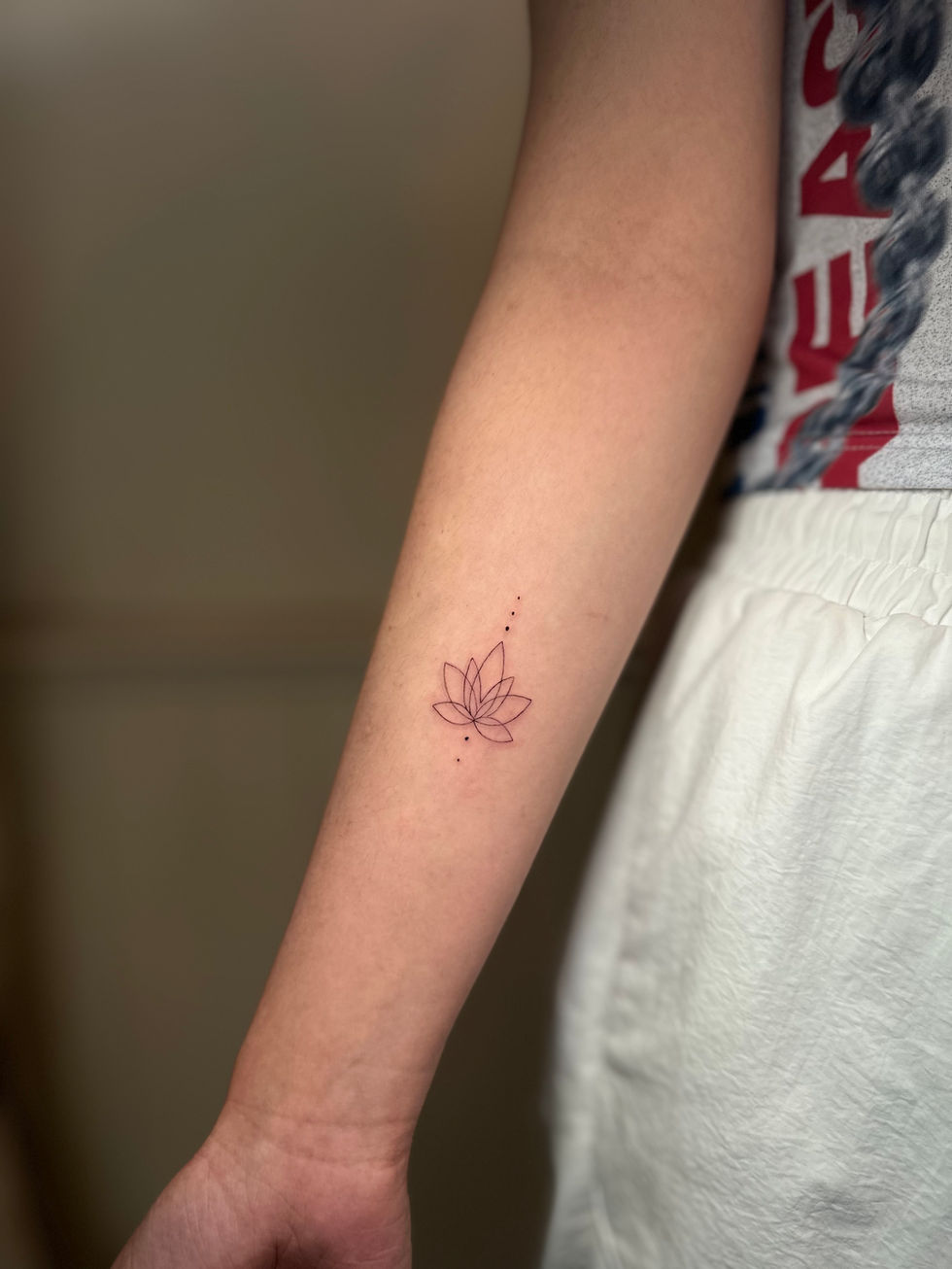 a woman has a tattoo of a lotus flower on her arm