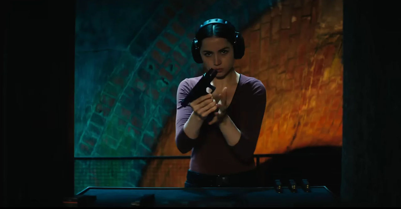 Eve cocking a gun in Ballerina