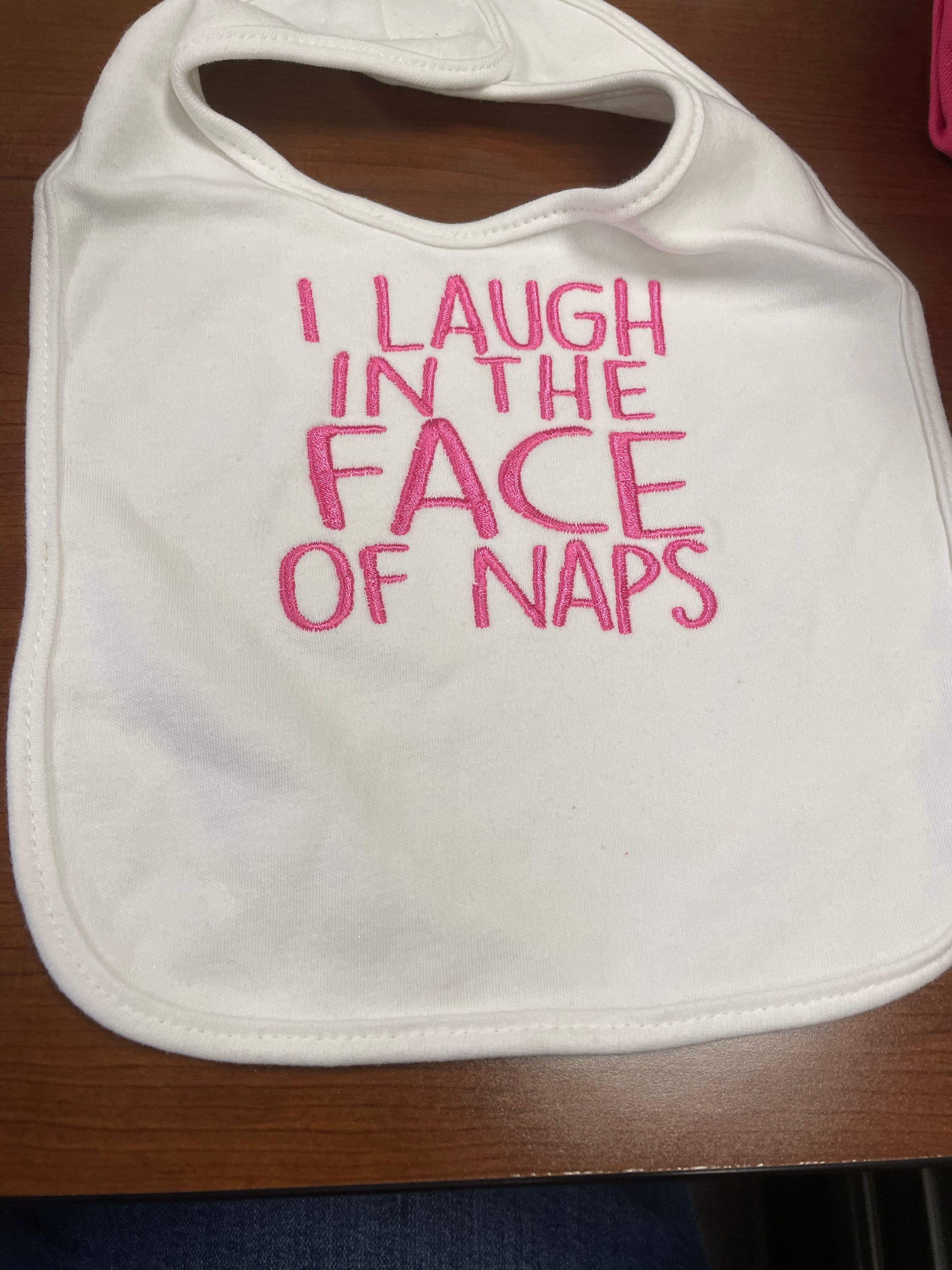 Bib embroidered with I laugh in the face of naps in hot pink