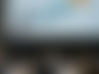 A leader presenting to a large employee townhall meeting  with a backdrop screen showing a journey map, illustrating progression from current state to future vision.