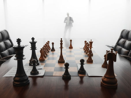 A professional photograph of a boardroom table with partially completed chess pieces, strategic documents with blank spaces, and an executive standing confidently at the edge of fog—suggesting forward movement despite incomplete visibility.