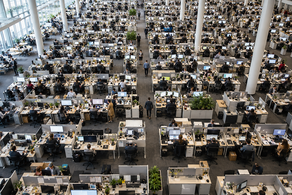 Aerial view of a large, densely occupied office floor — conveying the scale gap between small-team agility and large-organization complexity.