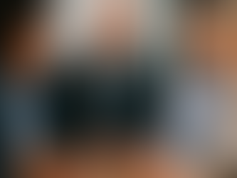 A professional photograph showing a diverse group of business professionals engaged in an open discussion around a conference table, with body language that conveys both engagement and mutual respect—depicting the balance of candor and safety.