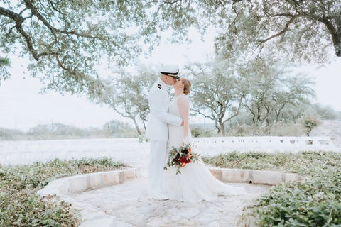 Bride and groom embracing in the courtyard of a Hill Country wedding venue in Texas.