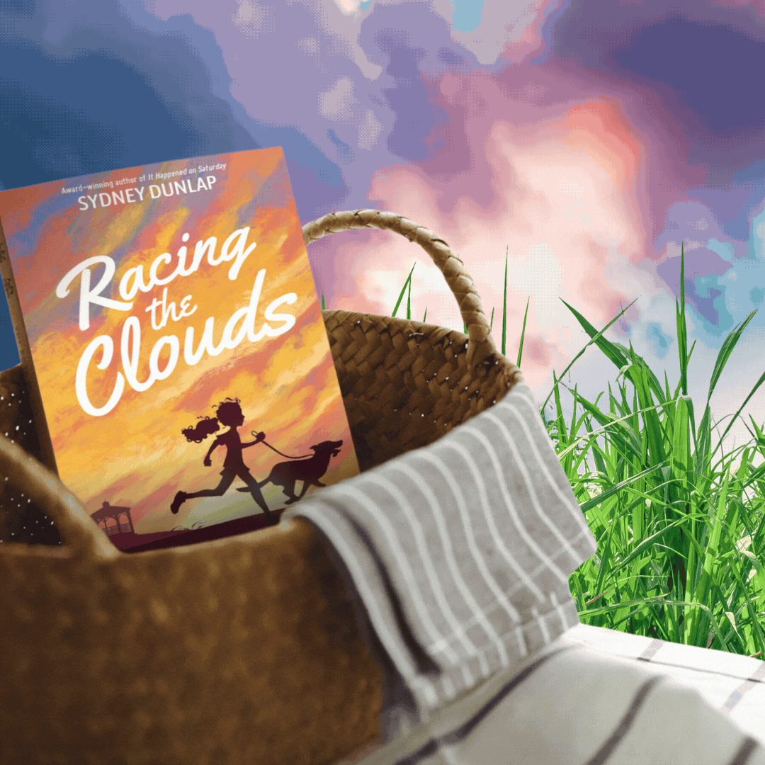 Book in basket with racing clouds in background. Book is titled "Racing the Clouds" by Sydney Dunlap