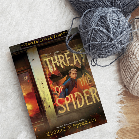 "Threat of the Spider" book next to yarn.