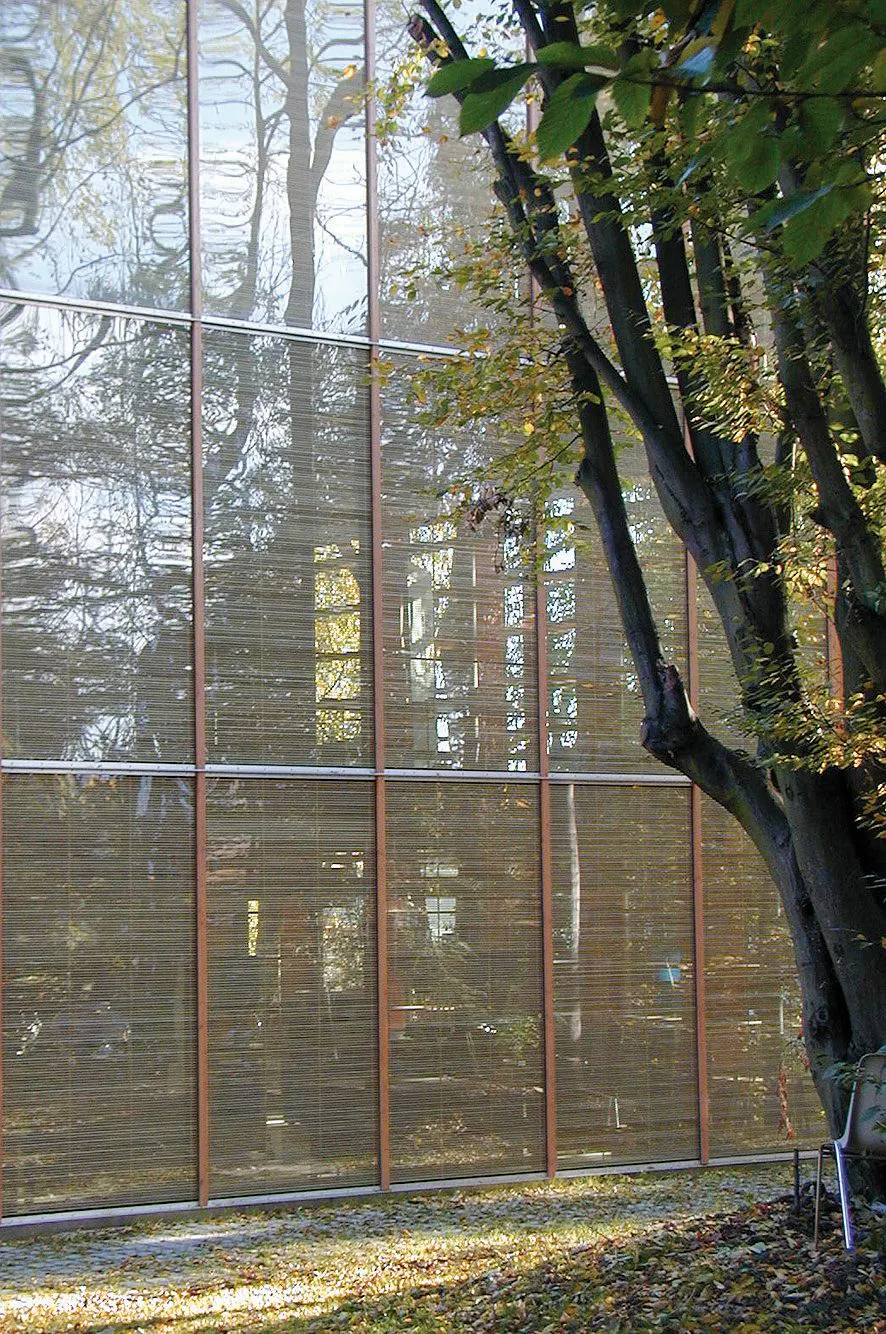 East facade with a vertical comprehensive shading element. Wooden slots are in between glass elements and block sunlight and avoid glare.